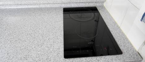 A kitchen with a granite countertop and a black induction cooktop.