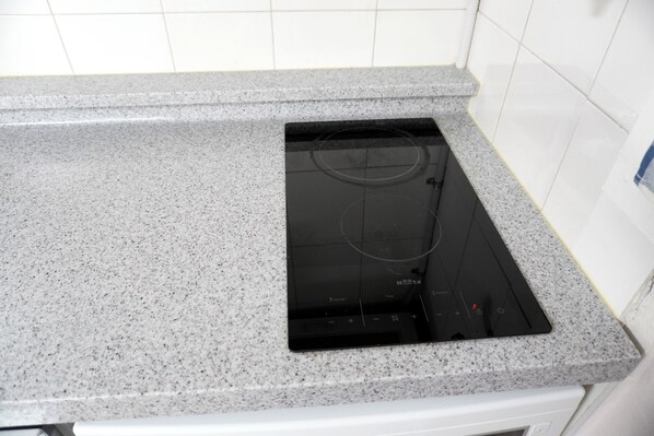 A kitchen with a granite countertop and a black induction cooktop.