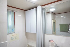 Ein Badezimmer mit Toilette, Waschbecken, Spiegel und Duschvorhang.