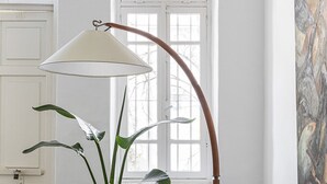A room with a green sofa, a floor lamp, a potted plant, and a window with a view. - The Gem of Neve Tzedek by Sea N' Rent (Tel Aviv)