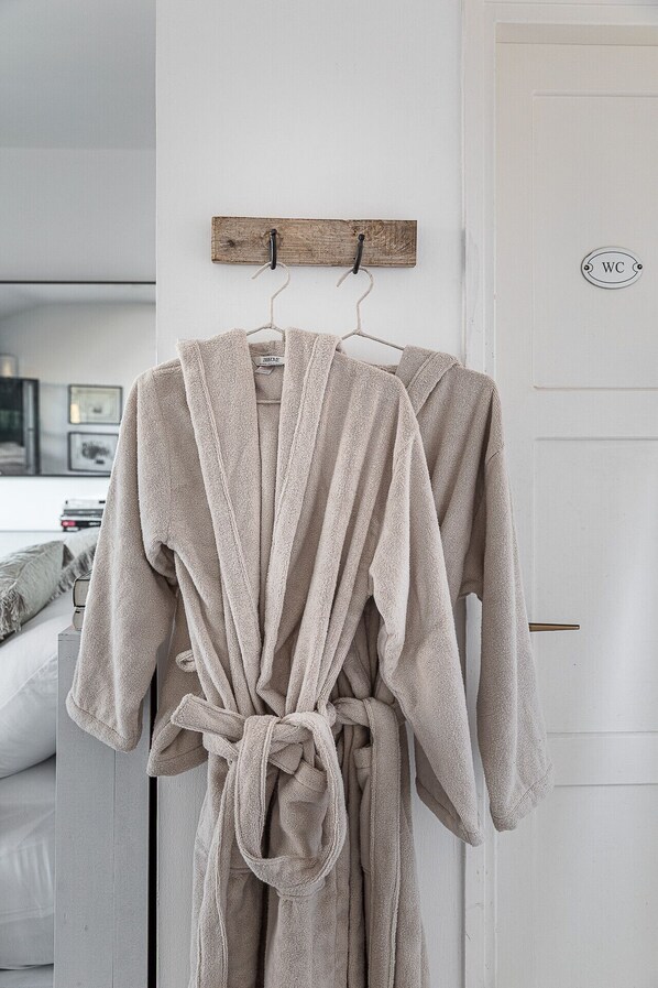 A bathroom with a white door, a wooden sign above the door, and a towel rack with two towels. - The Gem of Neve Tzedek by Sea N' Rent (Tel Aviv)