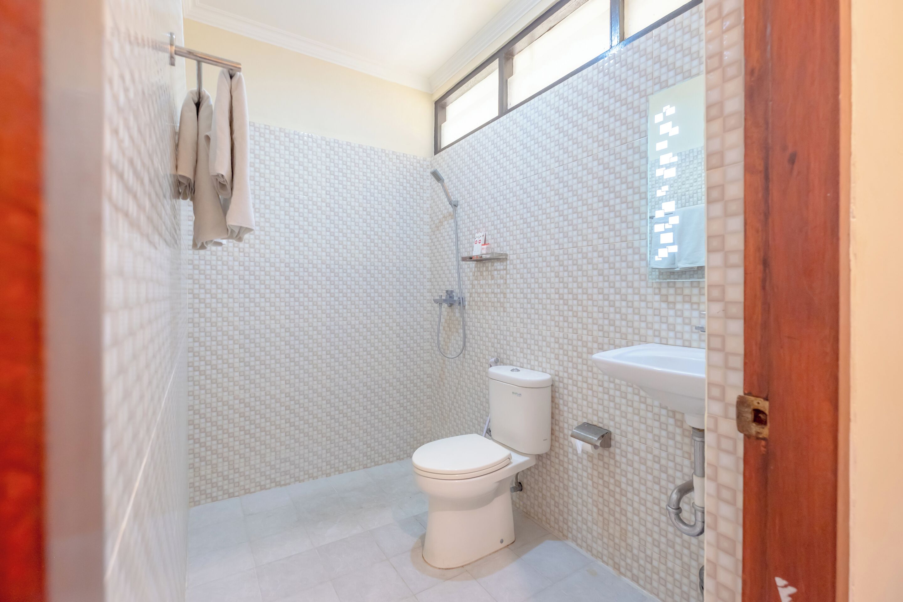 A bathroom with a toilet, shower, and sink.
