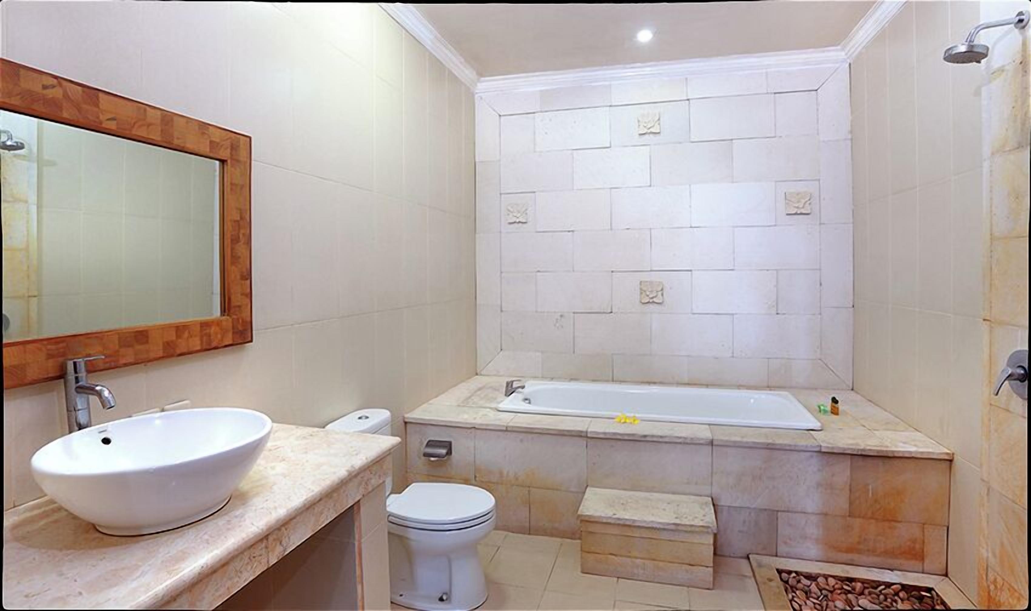 Un baño con un lavamanos grande de color blanco, un inodoro, una bañera y una ducha.