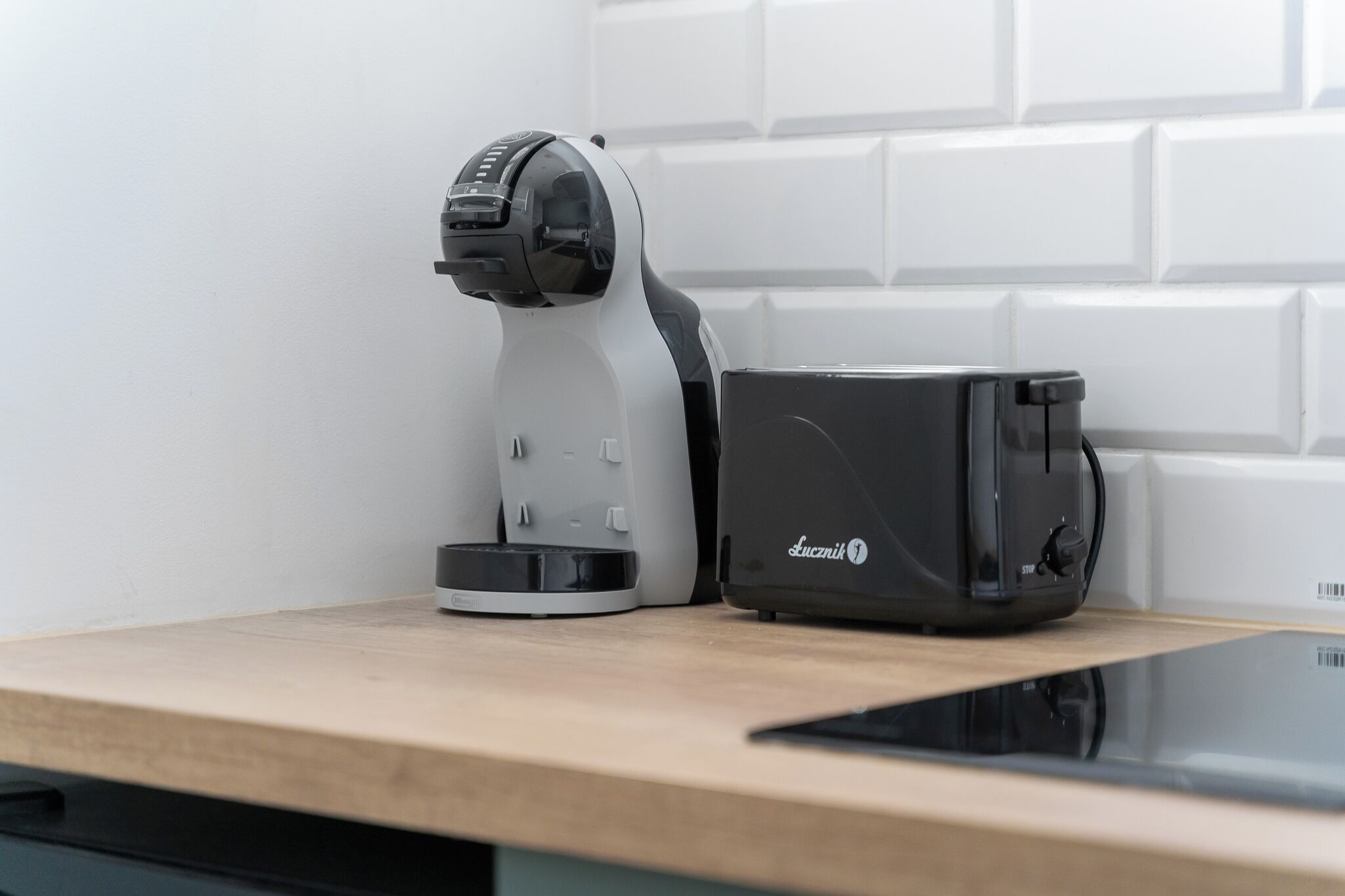 Une cuisine avec une machine à café et un grille-pain posés sur un plan de travail en bois.
