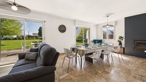 A modern dining area with a table set for four, surrounded by chairs.