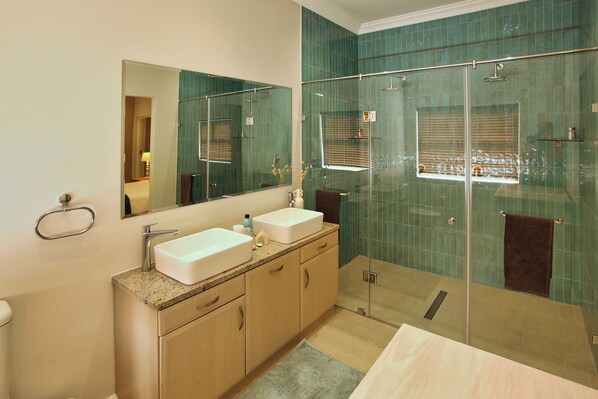 A modern bathroom with two sinks, a large mirror, and a glass-enclosed shower. - Bella Calypso, Langebaan, 8-sleeper (Langebaan)
