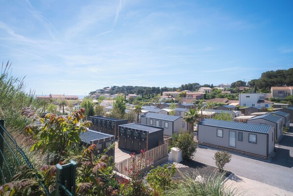A residential area with mobile homes, a wooden fence, and a clear sky. - Camping Domaine des Tamaris (Martigues)