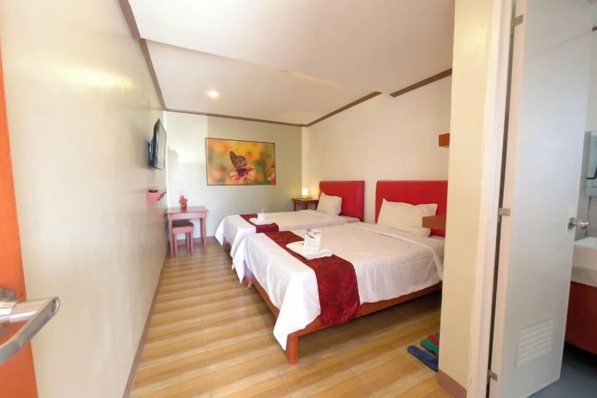 Una habitación de hotel con una cama grande, un escritorio y una silla.