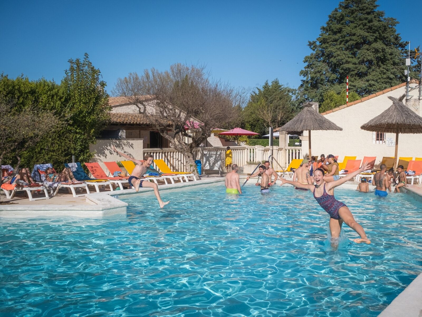 Una piscina al aire libre, sillones reclinables de piscina