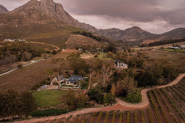 A rural landscape with a prominent mountain, vineyards, and a few houses. - Farm Keerweer (Stellenbosch)