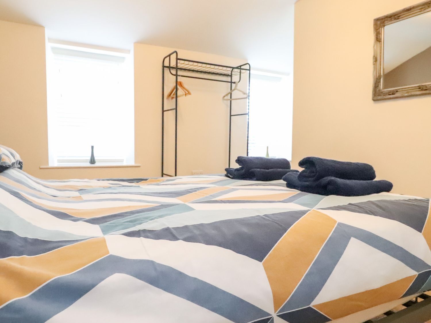 Un dormitorio con una cama, un armario metálico y una ventana.