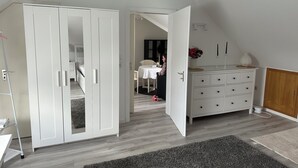 Quarto com guarda-roupa, penteadeira e cama.