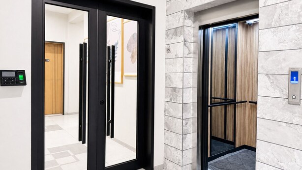 A modern elevator with a digital display, a wooden panel wall, and a floor number indicator. - Ixoras Hotel Lemba (Kinshasa)