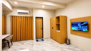 A hotel room with a desk, a wardrobe, an air conditioning unit, a television, and a tiled floor. - Ixoras Hotel Lemba (Kinshasa)