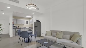 A modern apartment with a dining area, kitchen, and living room. - Manzil-1BR near JBR Beach & Blue Waters  (Dubai)