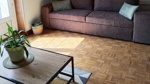 Un soggiorno con un divano marrone, un tavolino in legno e una pianta in vaso.