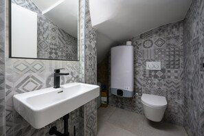 A bathroom with a white sink, a toilet, and a water heater. - Room in Porec by Old Town & Waterfront (Porec)