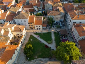An aerial view of a historic town with closely packed buildings, cobblestone streets, and a central square with a fountain. - Room in Porec by Old Town & Waterfront (Porec)