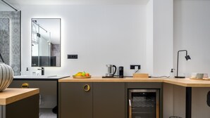 A modern kitchen with a built-in oven, a coffee maker, and a fruit bowl on the counter. - Room in Porec by Old Town & Waterfront (Porec)