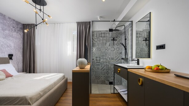 A modern bedroom with a bed, bedside table, and a nightstand with a vase. - Room in Porec by Old Town & Waterfront (Porec)