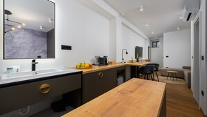 A modern kitchen with a wooden dining table, a large mirror, and a built-in oven. - Room in Porec by Old Town & Waterfront (Porec)
