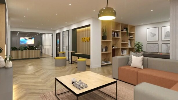 Een moderne woonkamer met een bank, salontafel en een televisie op de achtergrond.