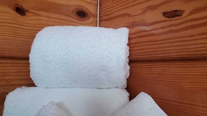 L’intérieur d’un chalet en bois, avec une serviette blanche et un savon liquide pour le corps de la marque Ocean Mist.
