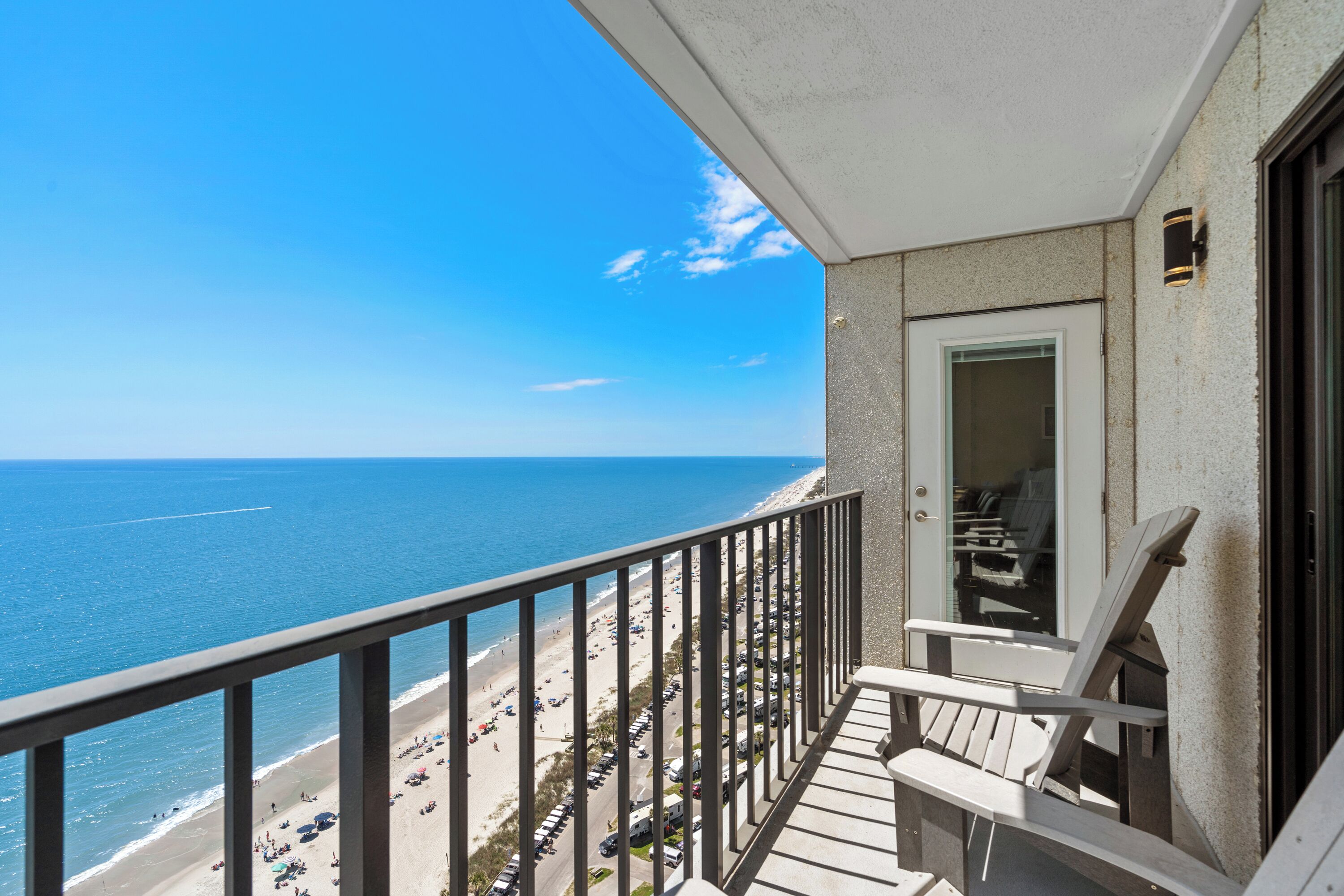 Un balcon avec vue sur la plage et l’océan.