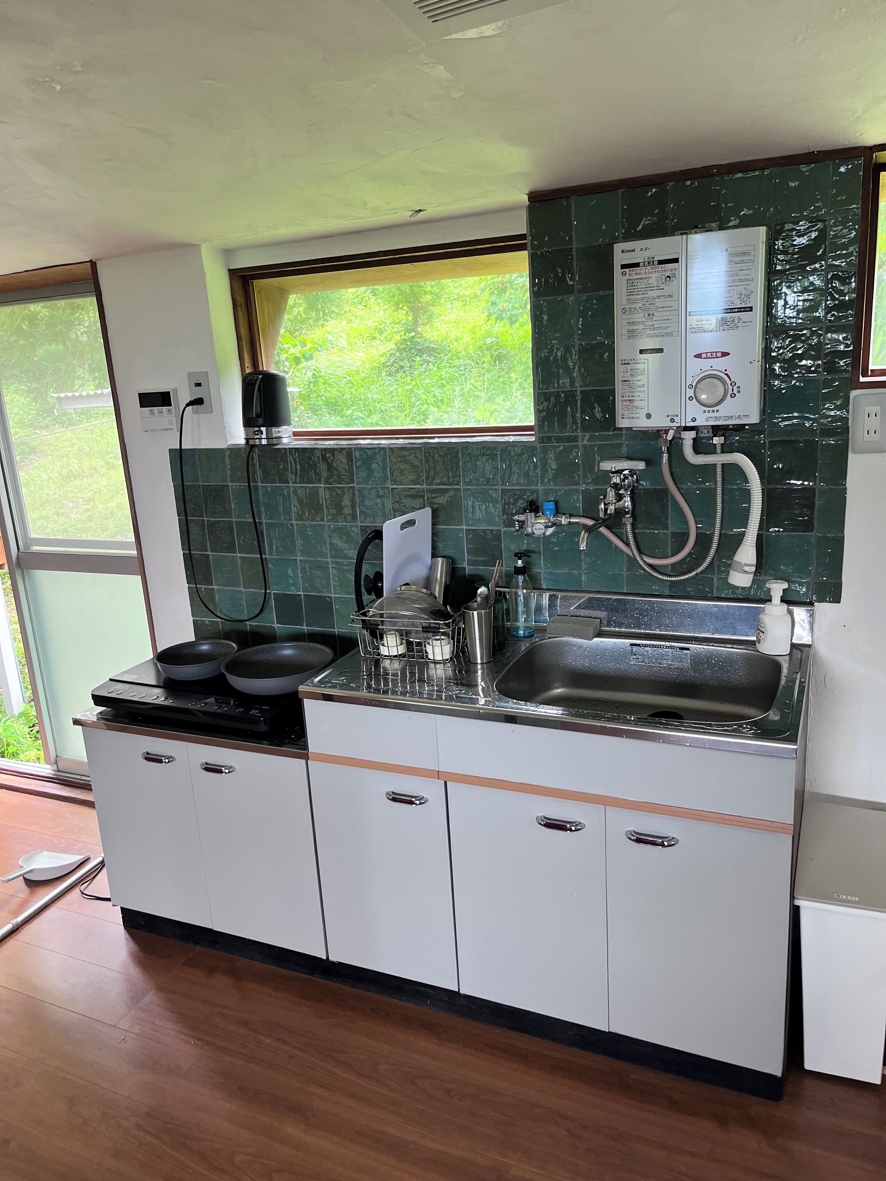 Een koelkast, een magnetron, een kookplaat, kookgerei, borden en bestek