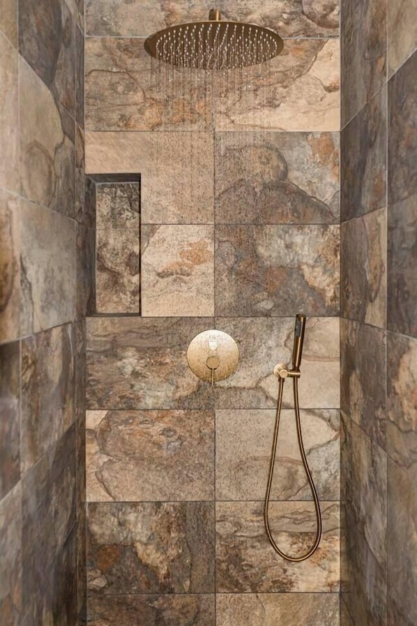 A shower with a rain showerhead, a handheld showerhead, and a control knob.
