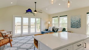 A spacious kitchen with a large island, a ceiling fan, and a view through the glass doors to the outdoors. - 3 Mi to Rockport Beach: Home Near Aransas Bay (Rockport)