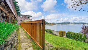A stone pathway leading to a wooden fence overlooking a lake with a distant view of mountains. - Walk to Beaches: Waterfront Home in Port Orchard! (Port Orchard)
