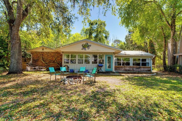 A rustic cabin with a stone exterior, a covered porch, and a fire pit. - Boat Slip & Fire Pit: Peaceful House (Homosassa)