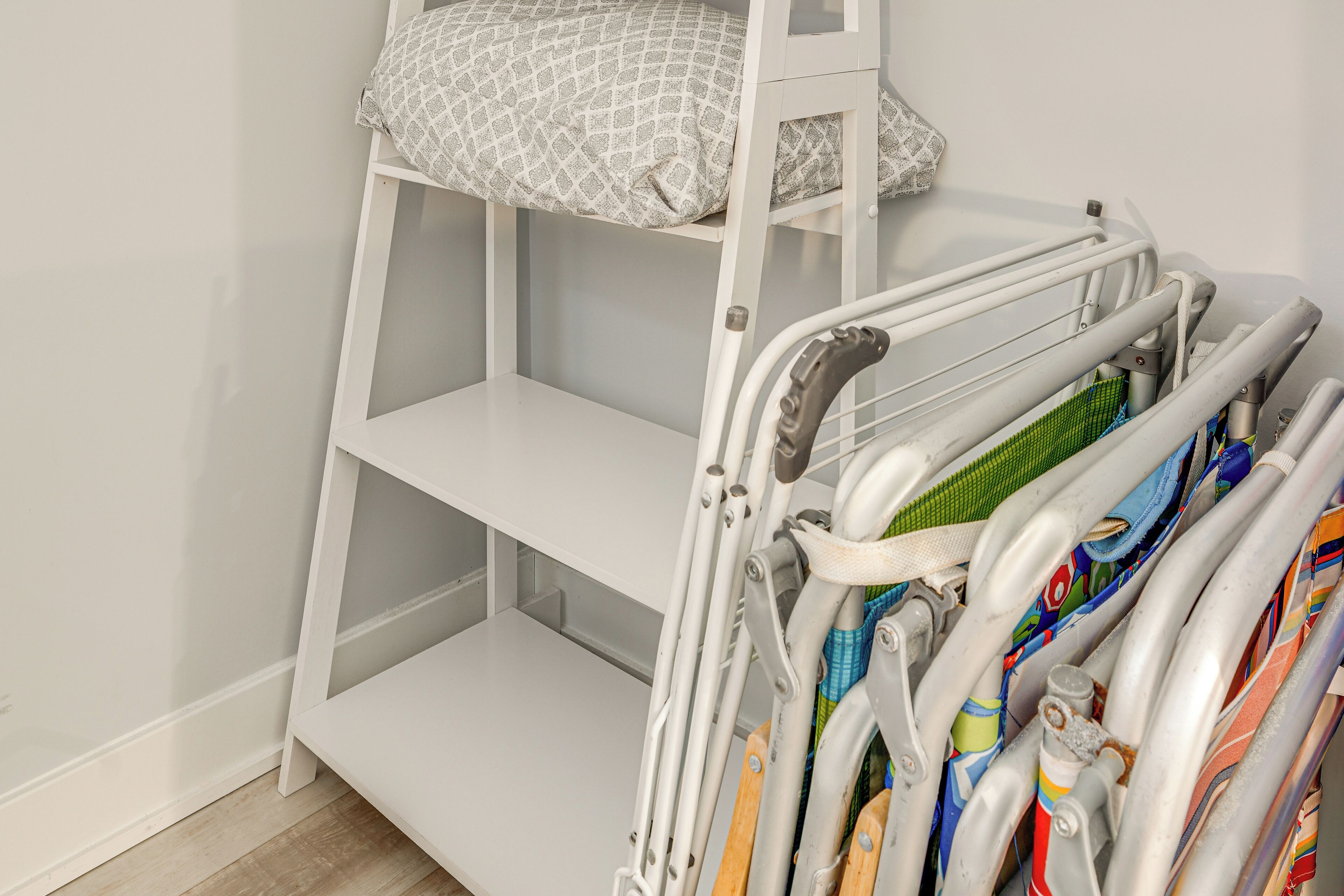 A bunk bed with a patterned pillow and a metal rack with colorful towels.