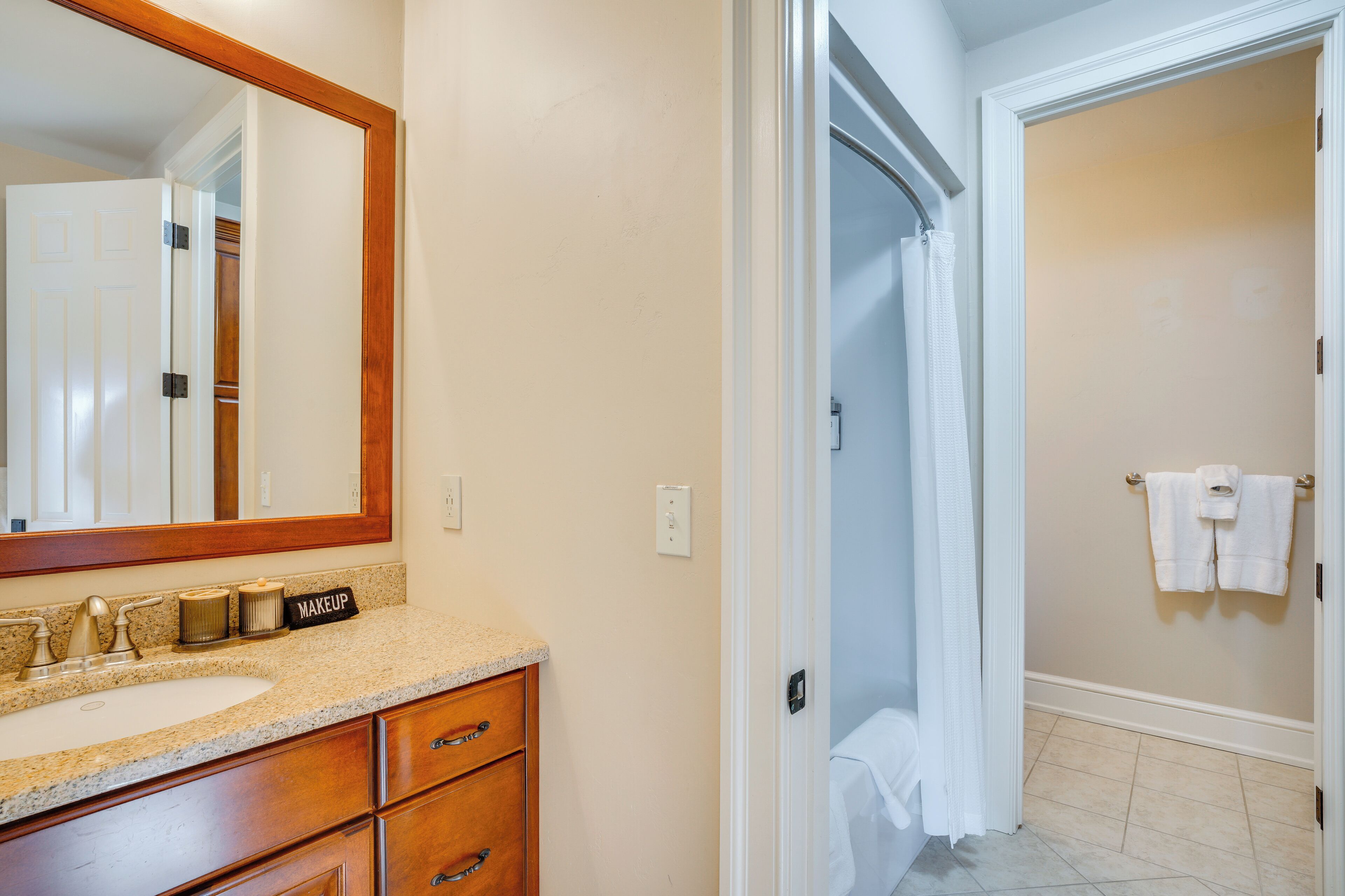 A bathroom with a sink, mirror, and towel rack.