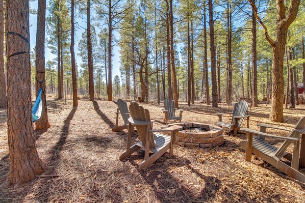 Un espace boisé aménagé avec des fauteuils Adirondack et un foyer.