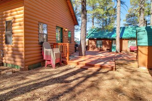 A log cabin with a porch, outdoor seating, and a small shed. - Cozy Cabin + Casita Pinetop Forest Retreat (Pinetop)