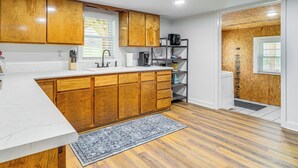 A kitchen with wooden cabinets, a marble countertop, and a built-in stove. - Peaceful Home w/ Patio on 30 Acres in Coxs Creek! (Coxs Creek)
