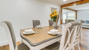 A dining area with a wooden table set for four, surrounded by upholstered chairs. - Peaceful Home w/ Patio on 30 Acres in Coxs Creek! (Coxs Creek)