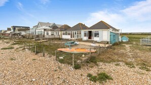 A row of houses with a swimming pool in the foreground. - The Coastal Crab - Family-friendly Three-bed Beach House in Pevensey (Pevensey)
