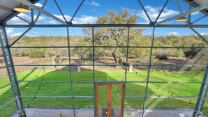 A conservatory with a view of a grassy field and trees. - The Plant at Kyle I Pool, Architectural Landmark (Kyle)