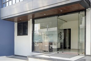 A modern building entrance with glass doors and a sign reading "Cosmos Green."
