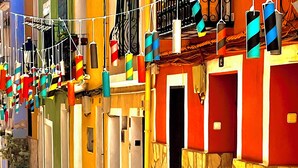 Un vicolo stretto con edifici colorati, pareti in pietra e un percorso in pietra ciottolata.