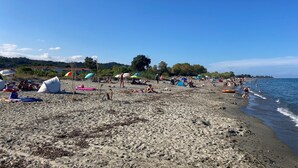 A beach with tents, umbrellas, and people relaxing. - Apartment with terrace and direct access to pool & beach (Poggio-Mezzana)