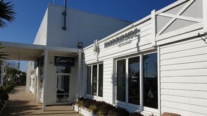 Un bâtiment blanc sur lequel on peut lire l’inscription : « Restaurant au bord du port ».