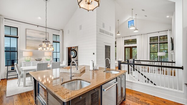A spacious kitchen with a large island, stainless steel appliances, and a modern chandelier.