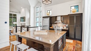 A spacious kitchen with a large island, modern appliances, and a view of the outdoors.
