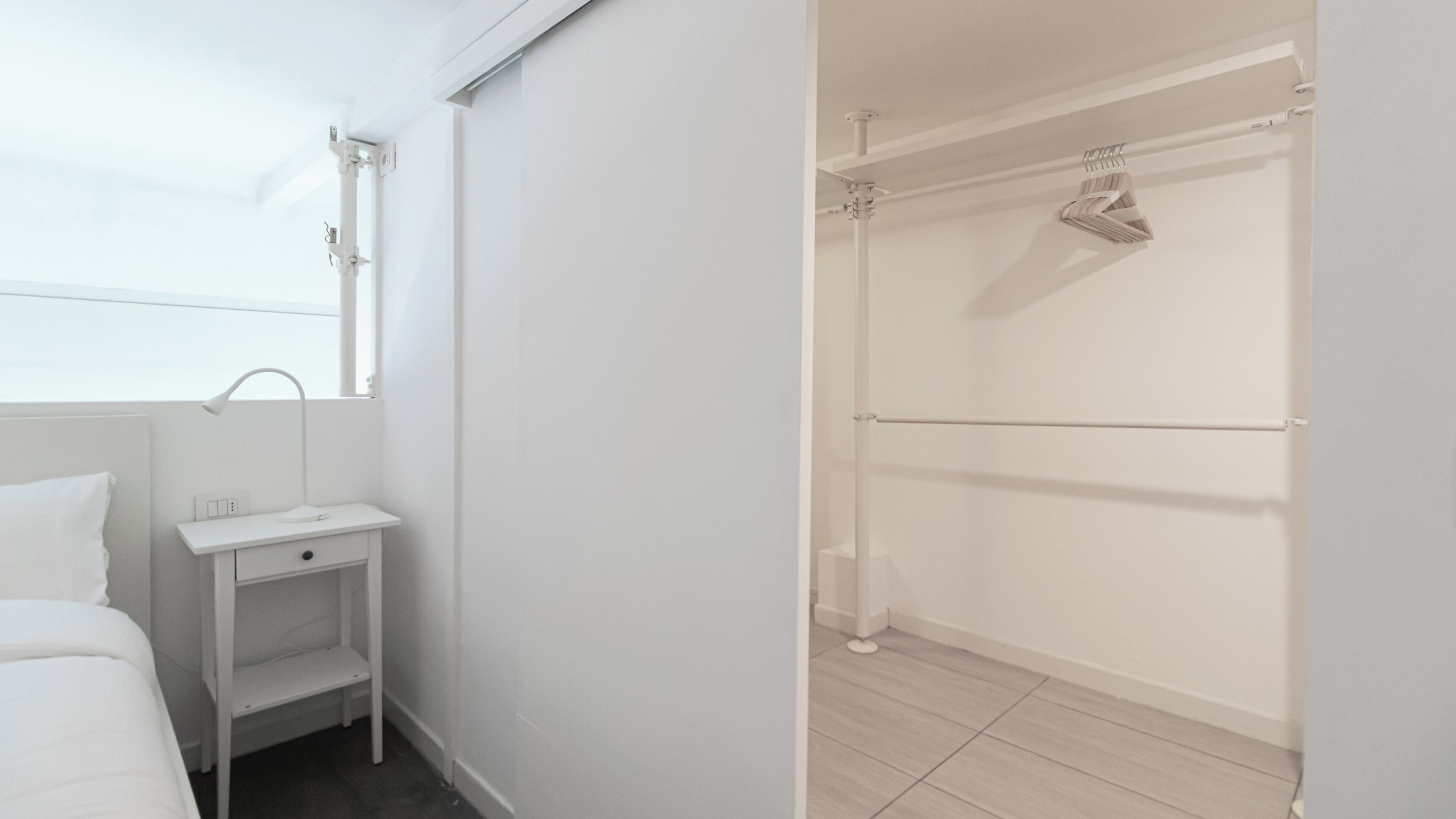 A modern bathroom with a shower, a small vanity with a mirror, and a toilet.