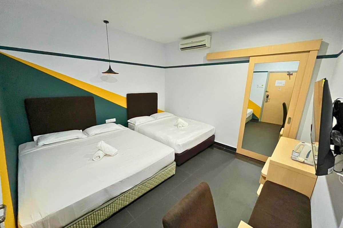 Een hotelkamer met twee bedden, een bureau, een stoel en een spiegel.