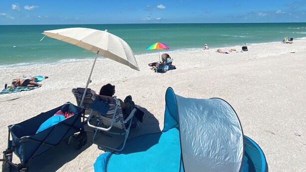 A beach scene with a clear sky, a sandy beach, and a few umbrellas. - Luxury, cozy, and Charming studio with WiFi and AC in brilliant Tampa (Tampa)